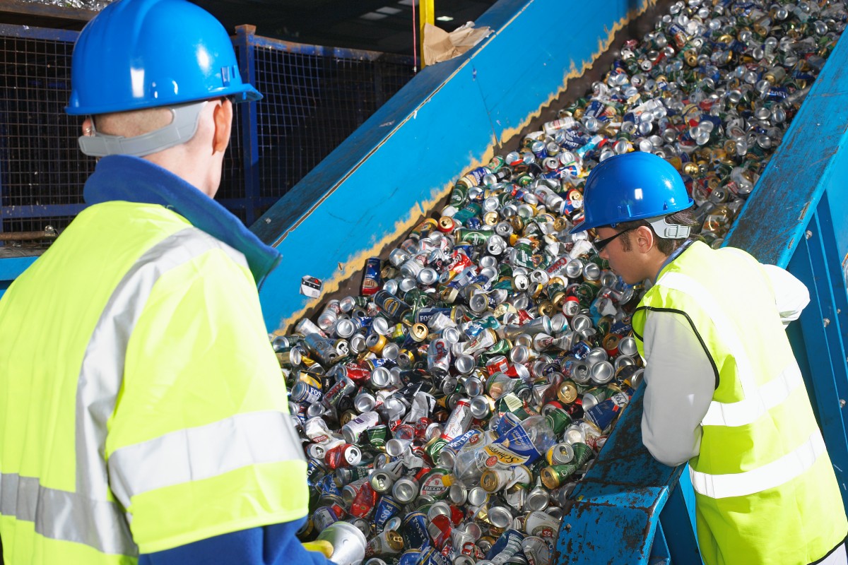 Fotografia colorida mostrando dois profissionais observando esteira de reciclagem de plástico-Metrópoles