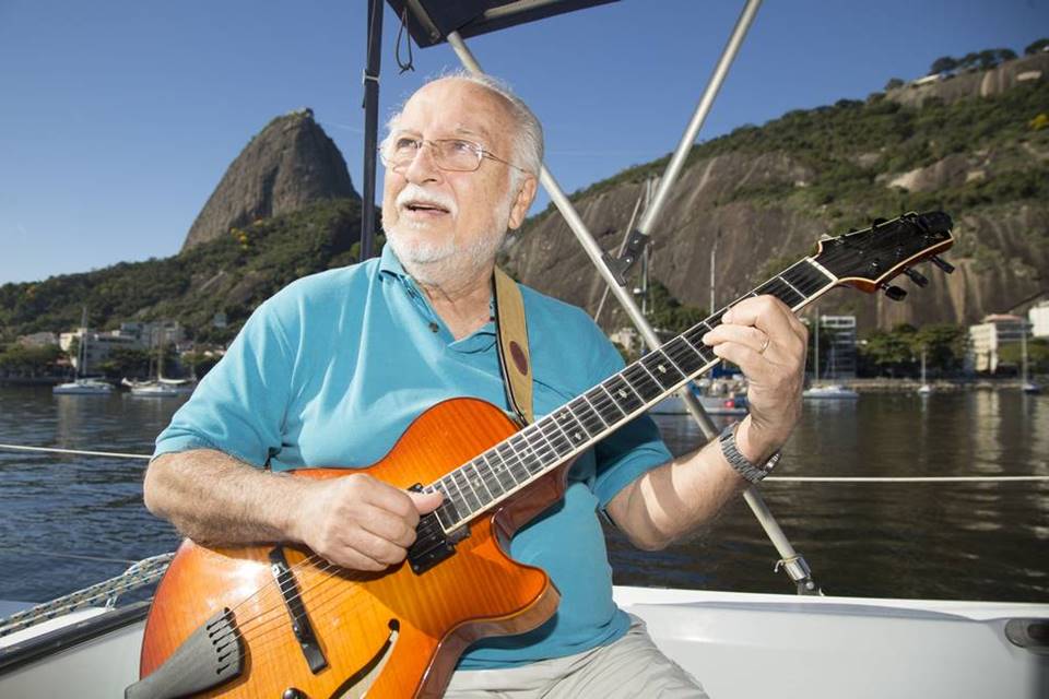 Roberto Menescal em um barco com o Corcovado, no Rio de Janeiro ao fundo - Metrópoles