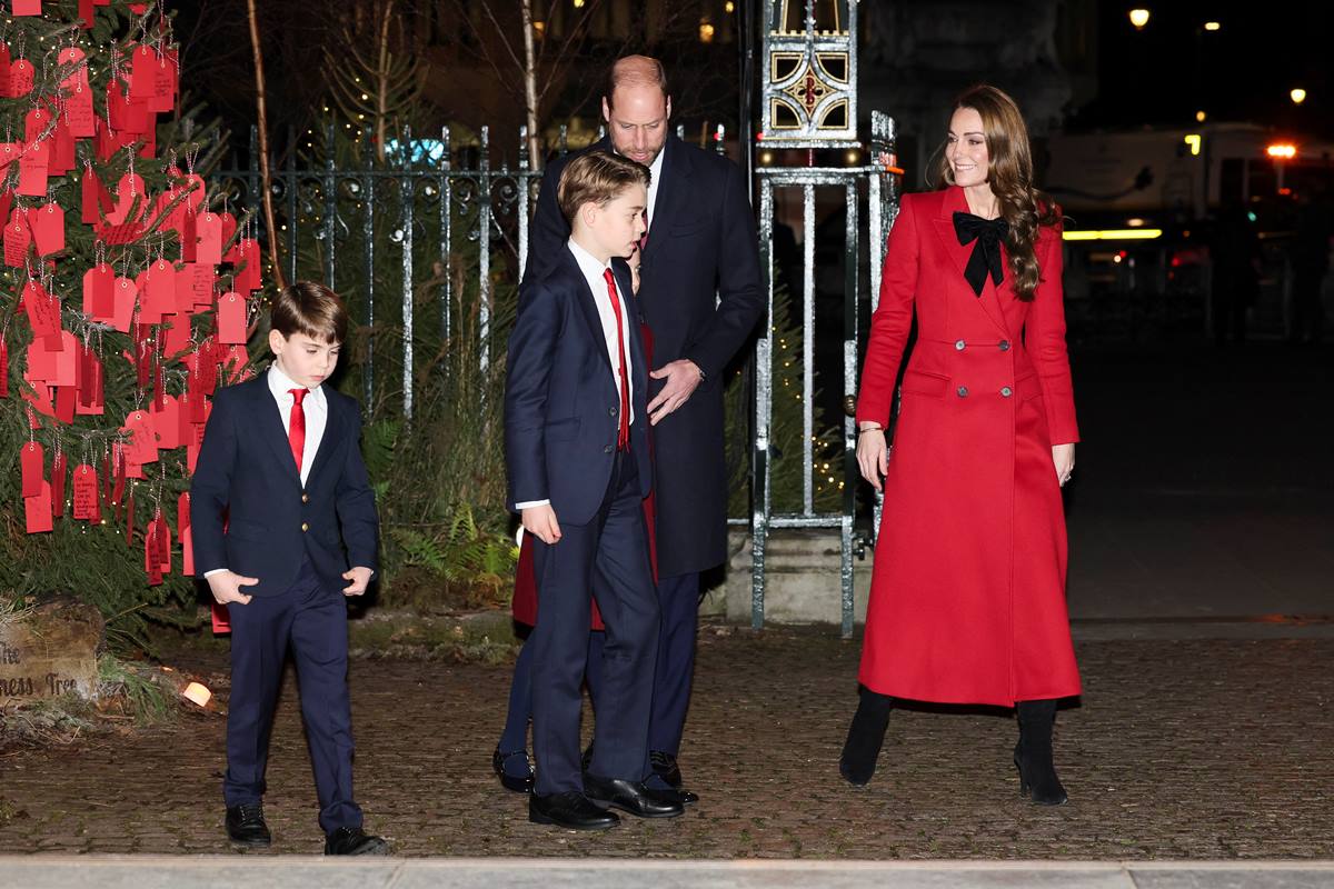 Foto colorida de dois meninos, um homem e uma mulher parados perto de uma árvore de Natal - Metrópoles