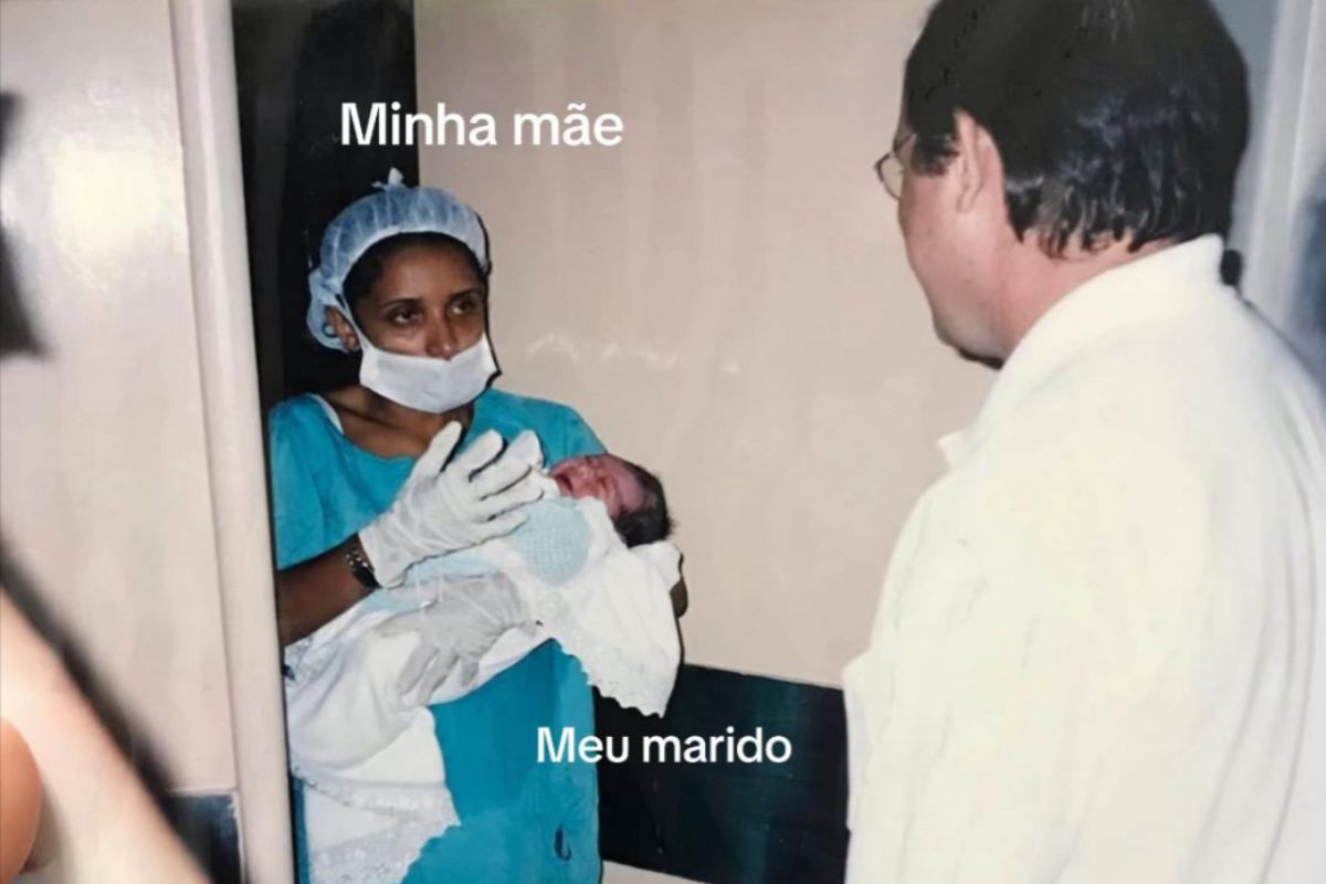 Foto colorida de uma enfermeira segurando um bebê no colo - Metrópoles